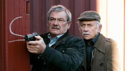 Günter und Edwin schleichen sich mit gezückten Waffen zum Container, in dem sie den Mörder vermuten.