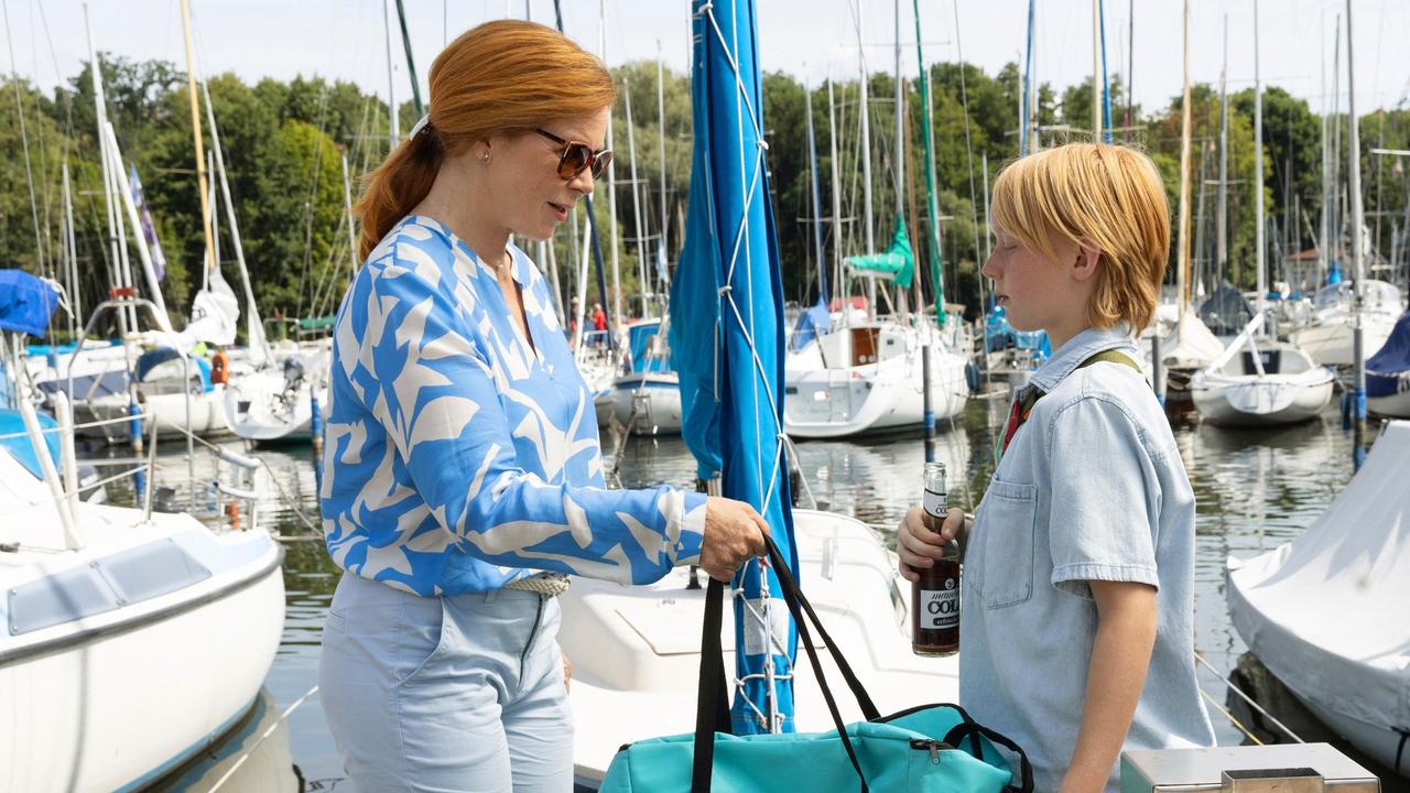 Alexandra Falkenbach (Marion Kracht) trägt ihrem Enkel Moritz (Shaun Miesner) auf, schon mal die Taschen auf ihr Boot zu bringen. Sie hat noch etwas zu erledigen.