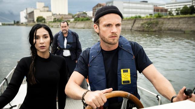 Bild: ARD/Laurent Trümper Gerade erst hat Arda Turan (Yasemin Cetinkaya), ehemals Hochleistungsschwimmerin, ihren Dienst bei der Wasserschutzpolizei Duisburg angetreten. Mit Gerhard Jäger (Markus John, h.) und Frank van Dijk (Niklas Osterloh) verfolgen sie ein Boot im Duisburger Hafen.