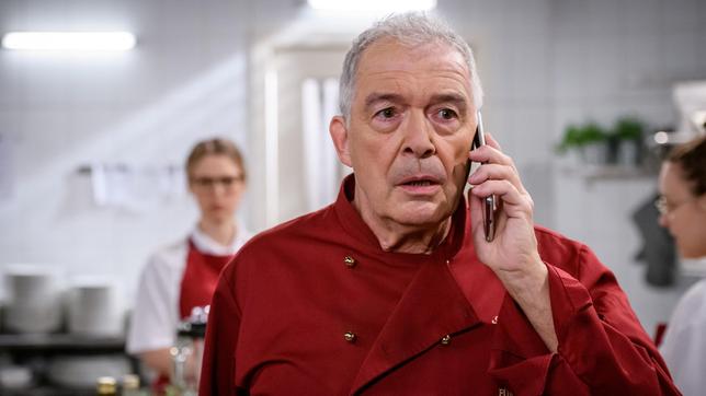André (Joachim Lätsch) erfährt am Telefon, dass Bettina einen Unfall mit einem Auto hat (mit Lena Conzendorf, l. und Komparsin).