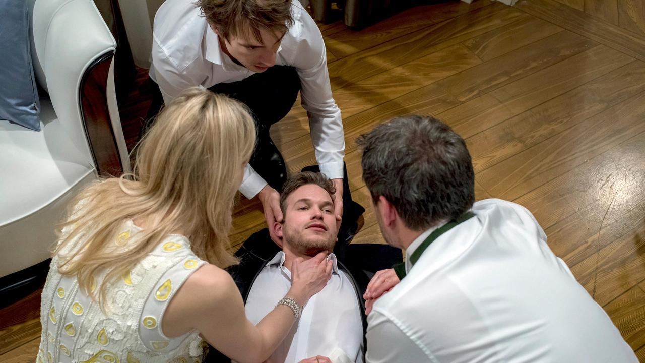 Christoph (Dieter Bach), Alicia (Larissa Marolt) und Viktor (Sebastian Fischer, h.) kümmern sich sorgenvoll um den angeschossenen Boris (Florian Frowein).