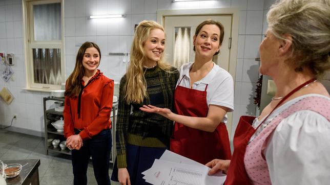 Clara (Jeannine Wacker) platzt mit Ella (Victoria Reich) in die Küche und überascht Tina (Christin Balogh), die sich gerade mit Hildegard (Antje Hagen) unterhält.