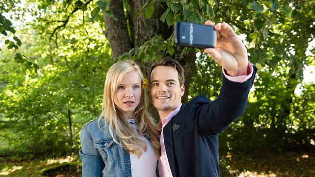 David (Michael N. Kühl) macht ein Foto von sich mit Luisa (Magdalena Steinlein), die davon allerdings gar nicht begeistert ist.