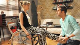 Sturm der Liebe: Sabrina sitzt im Rollstuhl und Nils hilft ihr in einem Schuh