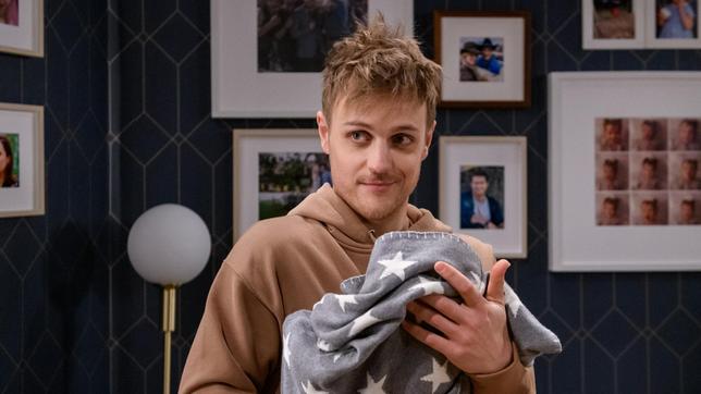 Max (Stefan Hartmann) nimmt Baby Anton zum ersten Mal auf den Arm.