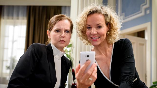 Bild: ARD/Christof Arnold Natascha (Melanie Wiegmann) zeigt Melli (Bojana Golenac), wie sie Michael per Handy überwachen kann.