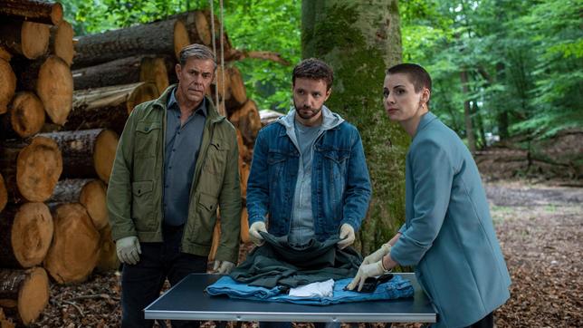 Nina (Julia E. Lenska), Gregor (Jonas Minthe) und Finn (Sven Martinek) untersuchen die Kleidung des Toten.