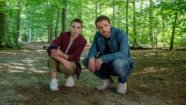 Nina (Julia E. Lenska) und Gregor (Jonas Minthe) sehen sich in einem Waldgebiet um.