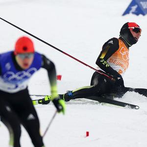 Ski nordisch/Kombination: Olympia, Mannschaft, Herren, 4 x 5 km Langlauf, Eric Frenzel (r) aus Deutschland liegt nach dem Wechsel erschöpft auf dem Boden. Links läuft Vinzenz Geiger aus Deutschland.