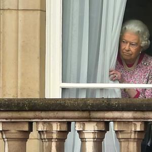 Die Queen schaut hinter einem Vorhang hervor.