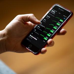 Eine Frau betrachtet in der App Stocks die Aktienkurse