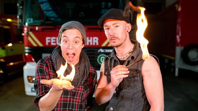 Bild: BR Checker Tobi (links) und Herausforderer und Feuerkünstler Michael Fuhr machen einen Feuertrick.