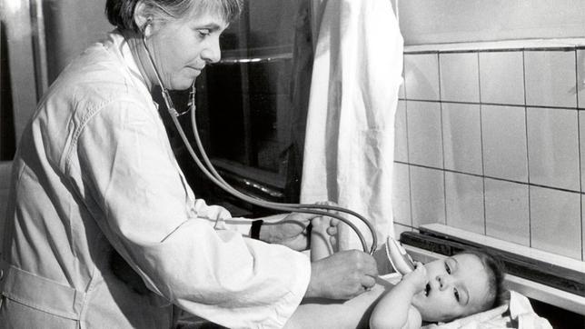 Die Charité liegt während der deutschen Teilung im Osten, in der DDR. Das berühmteste Krankenhaus Deutschlands im Spannungsfeld des Kalten Krieges. Ein Ort der Lehre, Forschung und Heilung – und das beste Krankenhaus im Ostblock. Doch Anfang der 60er Jahre blutet die Charité fast aus: Immer mehr Ärzte gehen in den Westen. Bis zum 13. August 1961. Fortan liegt das Krankenhaus im Mauerschatten. - Ingeborg Rapport untersucht Baby (Professorin/ 1. Lehrstuhl in Europa für Neonatologie).