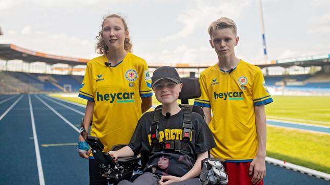 Bild: rbb/Nordisch Filmproduction Joshuas Herz schlägt für Eintracht Braunschweig, Kathi liebt Schalke 04. Carl Josef weiß: Beide lieben Fußball – und das verbindet! Seine heutigen Gäste spielen außerdem im Verein. Einziger Unterschied: In Kathis Mannschaft spielen Kinder mit Behinderungen zusammen mit Kindern ohne Behinderungen. Das macht Joshua neugierig... - Kathi (14) und Joshua (13) sind große Fußball-Fans – Carl Josef (16) überrascht beide mit einem Stadionbesuch.