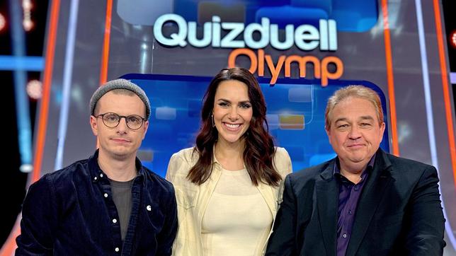 Bild: ARD/ITV Studios Moderatorin Esther Sedlaczek mit den Kandidaten des Teams "Lustig": Moritz Neumeier und Oliver Kalkofe.