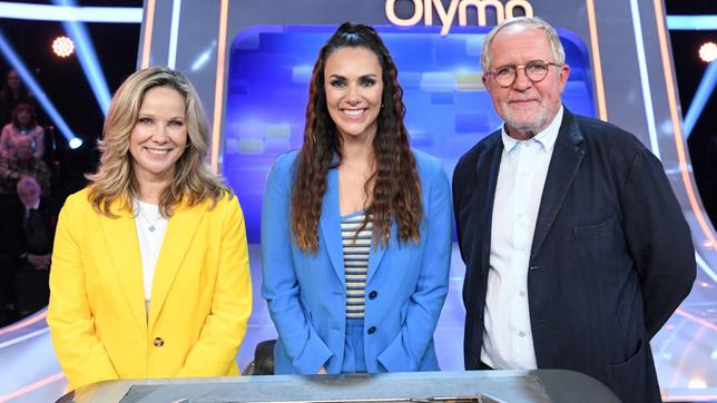 Bild: ARD/Uwe Ernst Moderatorin Esther Sedlaczek mit den Kandidat:innen des Teams "Traumpaar": Dem Ehepaar Ann-Kathrin Kramer und Harald Krassnitzer, beide Schauspieler.