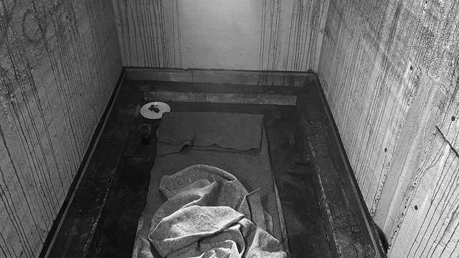 Nachgestellte Zelle, in der die Inhaftierten mit „weißer Folter“ traktiert werden: ein kleiner fensterloser Raum, hell und Tag/Nacht mit künstlichem Licht erleuchtet.