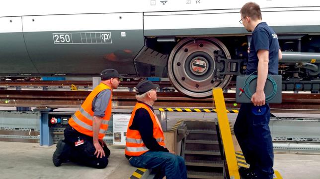 Bild: WDR/Flash Film v.l.n.r. Kai von Westerman, Armin Maiwald und ICE-Tester Sven begutachten das Rad unter einem Wagenkasten.