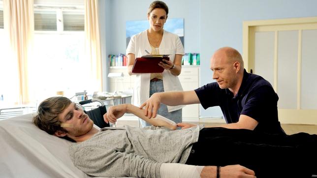 Bild: ARD Degeto/Hardy Spitz Vera Mundt (Rebecca Immanuel) und Dr. Chris Wegner (Simon Schwarz) sind verschiedener Meinung, wie Max (Leonard Proxauf) zu behandeln ist.