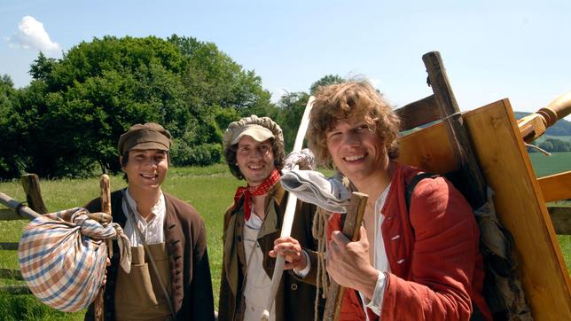 Bild: WDR/Hardy Spitz Zurück aus der Fremde: Max (Remo Schulze,re.) und seine Brüder Emil (Franz-Xaver Brückner, li) und Jockel (Christian Polito, Mitte) sind mit den Geschenken ihrer Lehrmeister auf dem Heimweg. Das "Tischlein deck dich", den Goldesel und den "Knüppel aus dem Sack" haben sie bei sich.