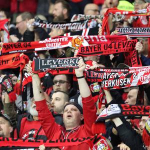 Was die Meisterschaft für Leverkusen bedeutet: Leverkusen-Fans halten Schals hoch