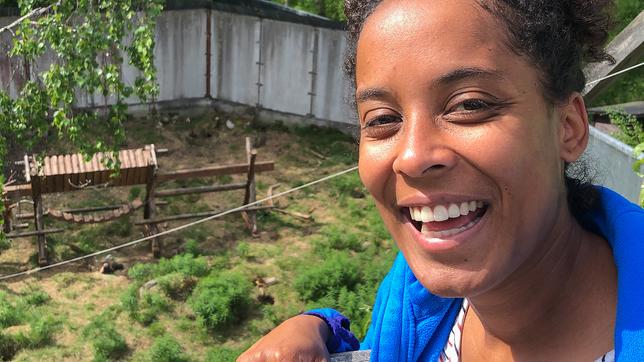 Pia vor dem Vielfraßgehege im Ranua Zoo, im Hintergrund Vielfraßweibchen Khurma.