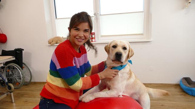 Mit dem stürmischen Therapiehund "Anton" macht Anna Übungen für das Gleichgewicht.
