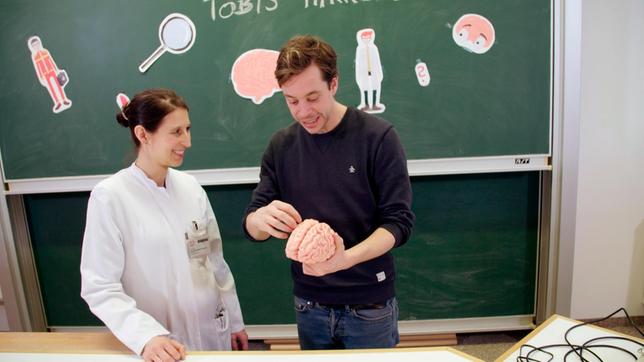 Bild: BR/megaherz gmbh Dr. Stephanie Ott-Mischo erklärt Tobi den Aufbau des Gehirns in der München Klinik Bogenhausen. Weiteres Bildmaterial finden Sie unter www.br-foto.de