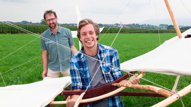 Checker Tobi (vorn) testet mit Norman Bernschneider den Otto Lilienthal-Gleiter. 