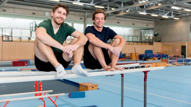 Bild: BR Tobi (rechts) checkt mit Turn-Trainer Erik, was er an den Geräten so drauf hat. Zum Beispiel am Barren, auf dem die beiden gerade sitzen.
