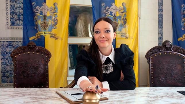Silvana (Mascha Müller) sitzt im Spiegelsaal am Jurypult. 