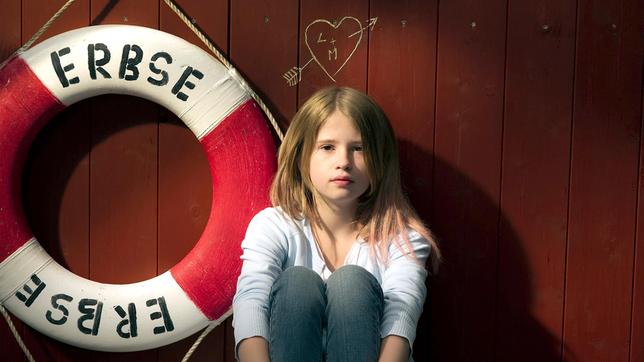 Die 11-jährige Lola (Tabea Hanstein) sitzt auf dem Hausboot, das den Namen „Erbse“ trägt.