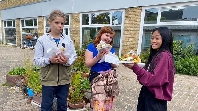 Es gibt ihn an fast jeder Ecke – den Döner. Daher führt die heutige Spurensuche Elisabeth u. a. in eine Döner-Drehspießfabrik. Nhung ermittelt mit Koch Felix Denzer, ob es auch fleischlose Alternativen zum Nachmachen gibt und Ole widmet sich mit Viktoria Ganß den chemischen Fragen rund um Hefe und Gemüse. Ein spannender Fall! - Ole, Elisabeth und Nhung lassen sich ihren Döner schmecken.