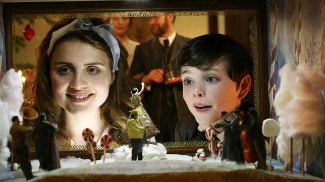 Marie Stahlbaum (Mala Emde) und Fritz Stahlbaum (Leonard Seyd) schauen erstaunt in die Zuckerwelt. (Im Hintergrund: die Eltern Frau Stahlbaum (Brigitte Hobmeier), Vater Stahlbaum (Jürgen Tonkel).