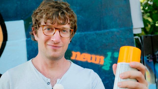 Bild: WDR/tvision Robert steht mit einer Spraydose vor einer Graffiti-Wand, auf die das neuneinhalb-Logo gesprüht wurde.
