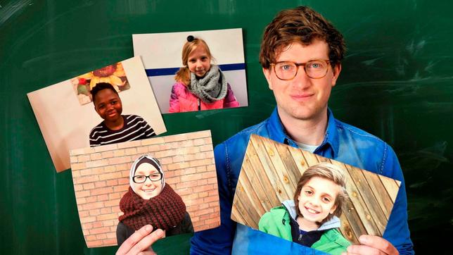 Robert steht vor einer grünen Schultafel. Er hält Bilder von vier unterschiedlich aussehenden Kindern in den Händen.