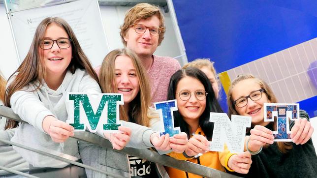 Bild: WDR Robert zusammen mit einigen Schülerinnen im Schüler-Forschungslabor des DLR. Die Mädels halten die Buchstaben M – I – N – T in die Kamera.
