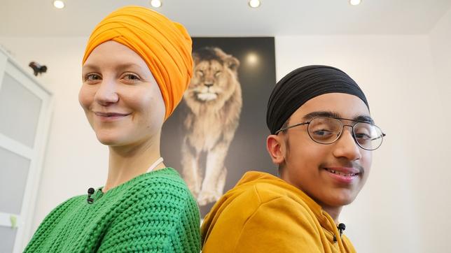 Jana mit Gurjas, Rücken an Rücken. Beide tragen einen traditionellen Dastar, einen Turban.