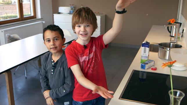 Nik (re.) lebt mit seiner Familie in Stuttgart. Für seine Gäste kocht er bei "Schmecksplosion" heute seine beiden Lieblingsgerichte: Milchreis und selbstgemachtes Himbeereis. Für diese besondere Kombination bekommt er tatkräftige Unterstützung von seinem besten Freund Nino.