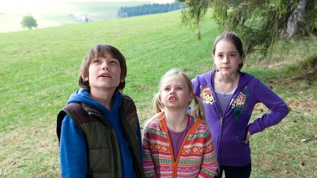 Greta (Enya Elstner) (rechts) mit Jonas (Fynn Henkel) und Lilie (Lotte Hanné) stehen am Wald und schauen zum ausgebüchsten Vogel.