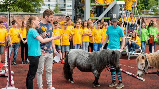 Bild: SWR/Alexander Kluge Die Reiterinnen Simone und Fiona vom Ponyhof Müller in Denkendorf sind begeisterte Shetty-Sportlerinnen. Zusammen mit ihrer Trainerin Tanja zeigen sie Moderator Johannes Zenglein, wie der Sport funktioniert und warum er so vielseitig ist.