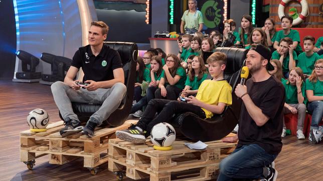 Bild: SWR/Sabine Stumpp FIFA-Profi Benedikt Saltzer zeigt was er an der Konsole kann. Da haben die Schulkinder und Moderator Johannes keine Chance.