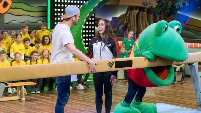 Bild: SWR/Alexander Kluge Moderator Johannes Zenglein mit Turn-Star Tabea Alt. Frosch Günther macht auch am Schwebebalken eine gute Figur.