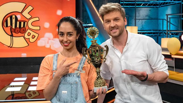 Bild: SWR/Patricia Neligan Noch hält das Moderatoren-Duo Muschda Sherzada und Johannes Zenglein den goldenen Tigerenten-Pokal in ihren Händen. Welches Team wird ihn wohl im fairen Wettkampf erspielen – die Frösche oder die Tigerenten?