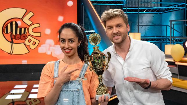 Bild: SWR/Patricia Neligan Noch hält das Moderatoren-Team Muschda Sherzada und Johannes Zenglein den goldenen Tigerenten-Pokal in ihren Händen. Die Geschwister Nilay und Nayla möchten diesen jedoch im fairen Wettkampf erspielen.