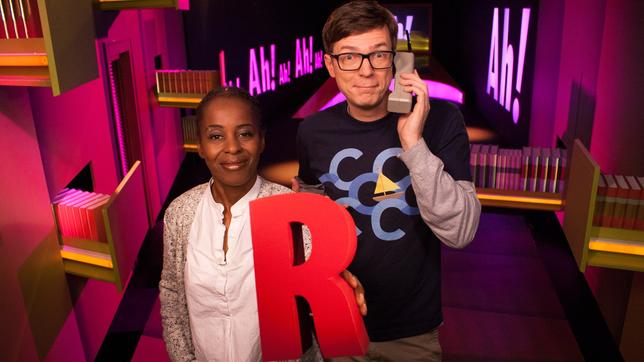 Shary und Ralph, Shary hält ein großes R in der Hand, Ralph sich einen Hörer ans Ohr