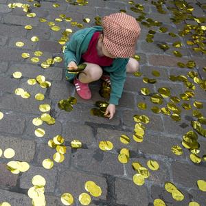 Kind sammelt goldenes Konfetti auf (Schweiz)