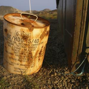 Rostiger Behälter mit Schmieröl für ein US-Militärfahrzeug nahe der ostgrönländischen Siedlung Kulusuk. Die US-Militärbasis wurde Ende der 1950er-Jahre errichtet und sollte eine Abschusbasis für Atomraketen werden.