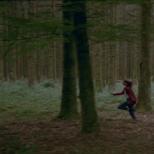 Ein Mädchen rennt durch den Wald.