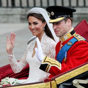 Herzogin Kate und Prinz William winken bei ihrer Hochzeit aus der Kutsche.